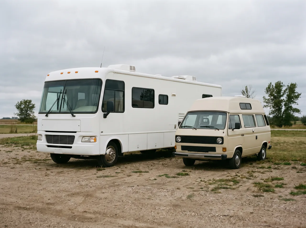 A full size motorhome and a small camper van parked next to each other, the difference in scale plain between them.
